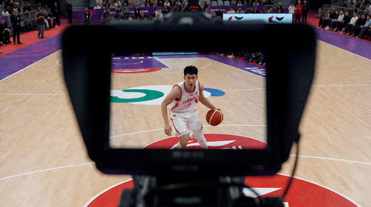 比赛现场直播机位拍摄球场，摄像机对准正在进行比赛的球员